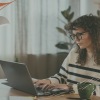 a woman using a laptop at a desk